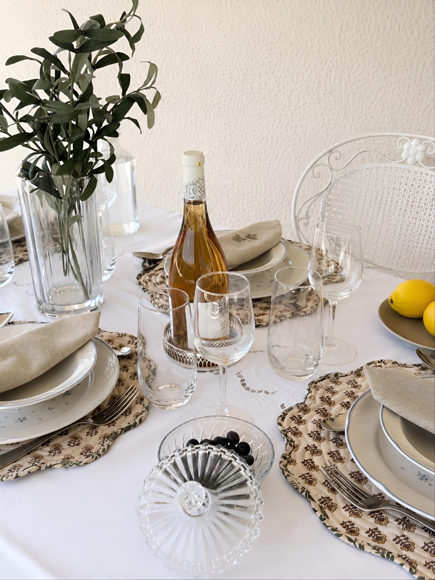 Terrace table set for aperitivo with rosé, olives and patterned linens