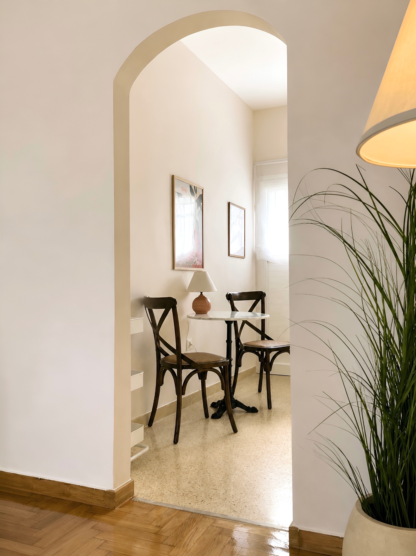 Arched passage to the breakfast nook with marble bistro table