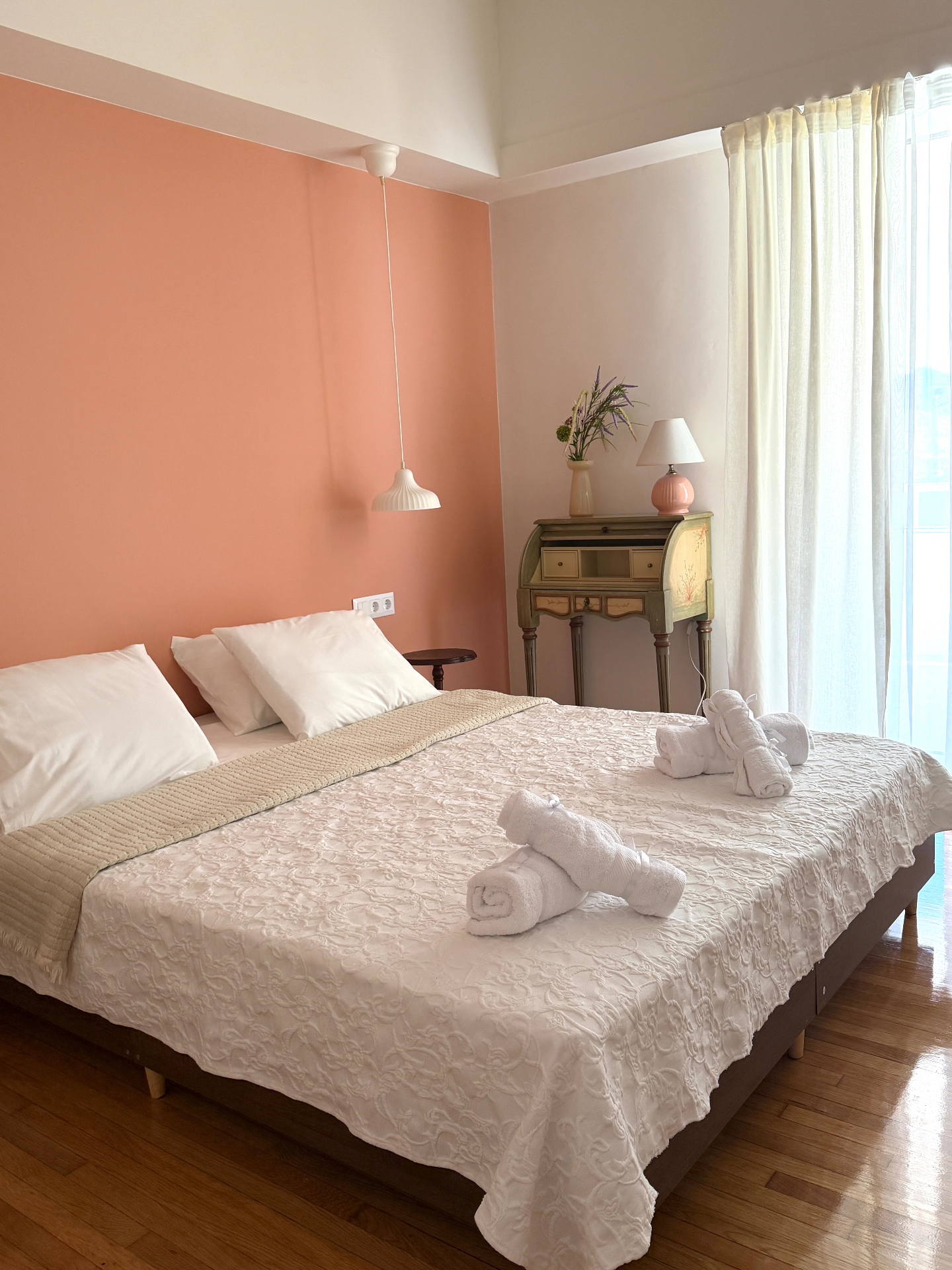 Softly lit bedroom with vintage writing desk by the window
