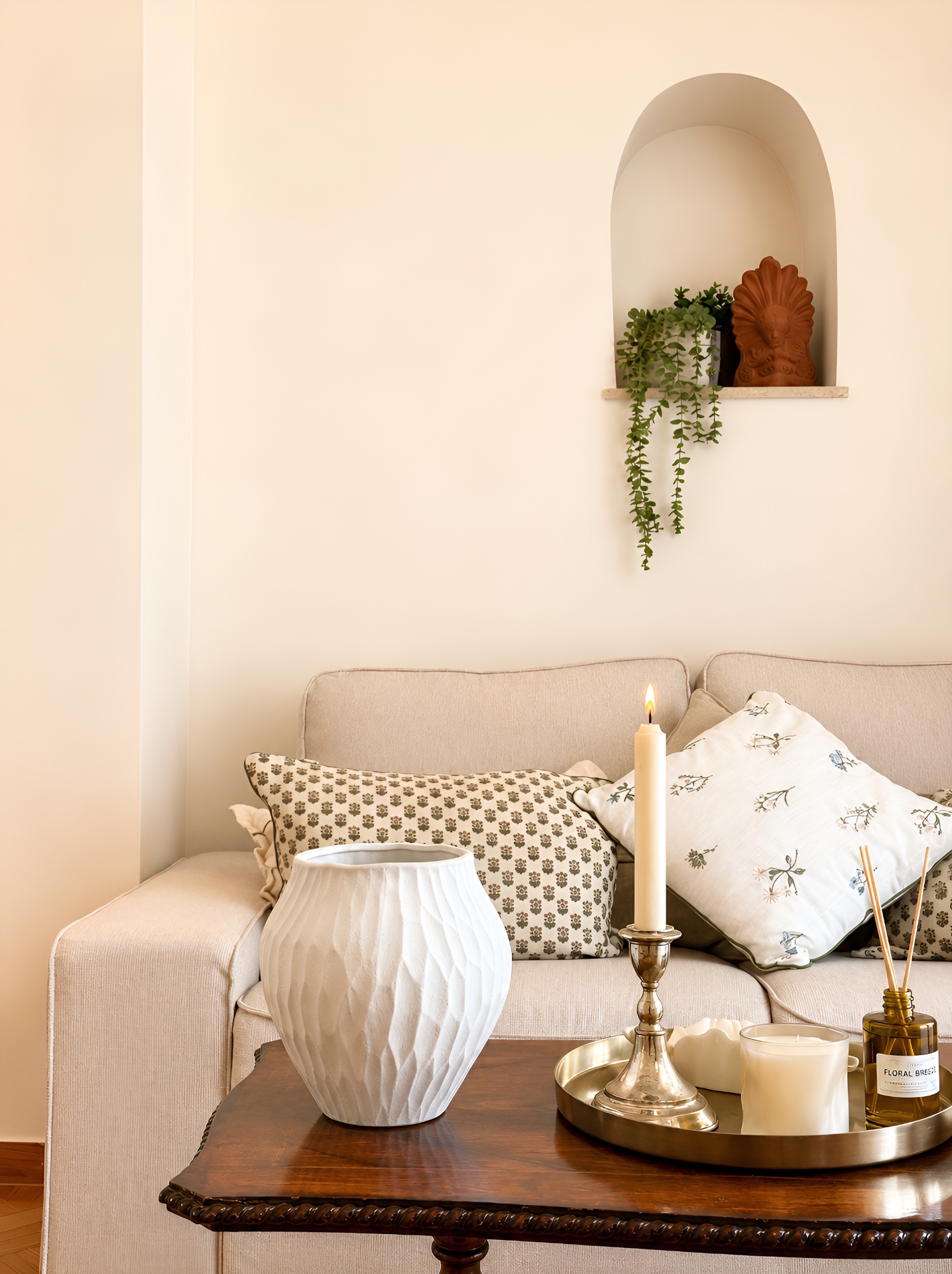 Sofa detail with candle, vase and arched shelf