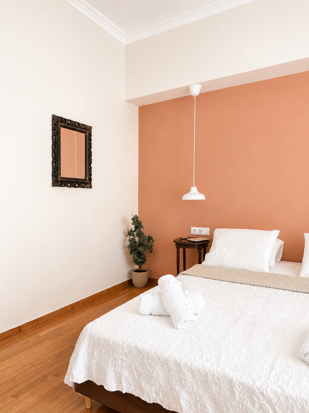 Bedroom corner with carved mirror frame and terracotta feature wall