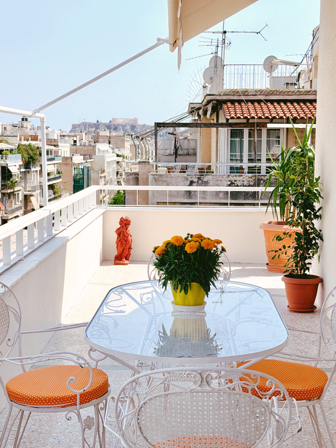 Sunny terrace dining setup with Acropolis view