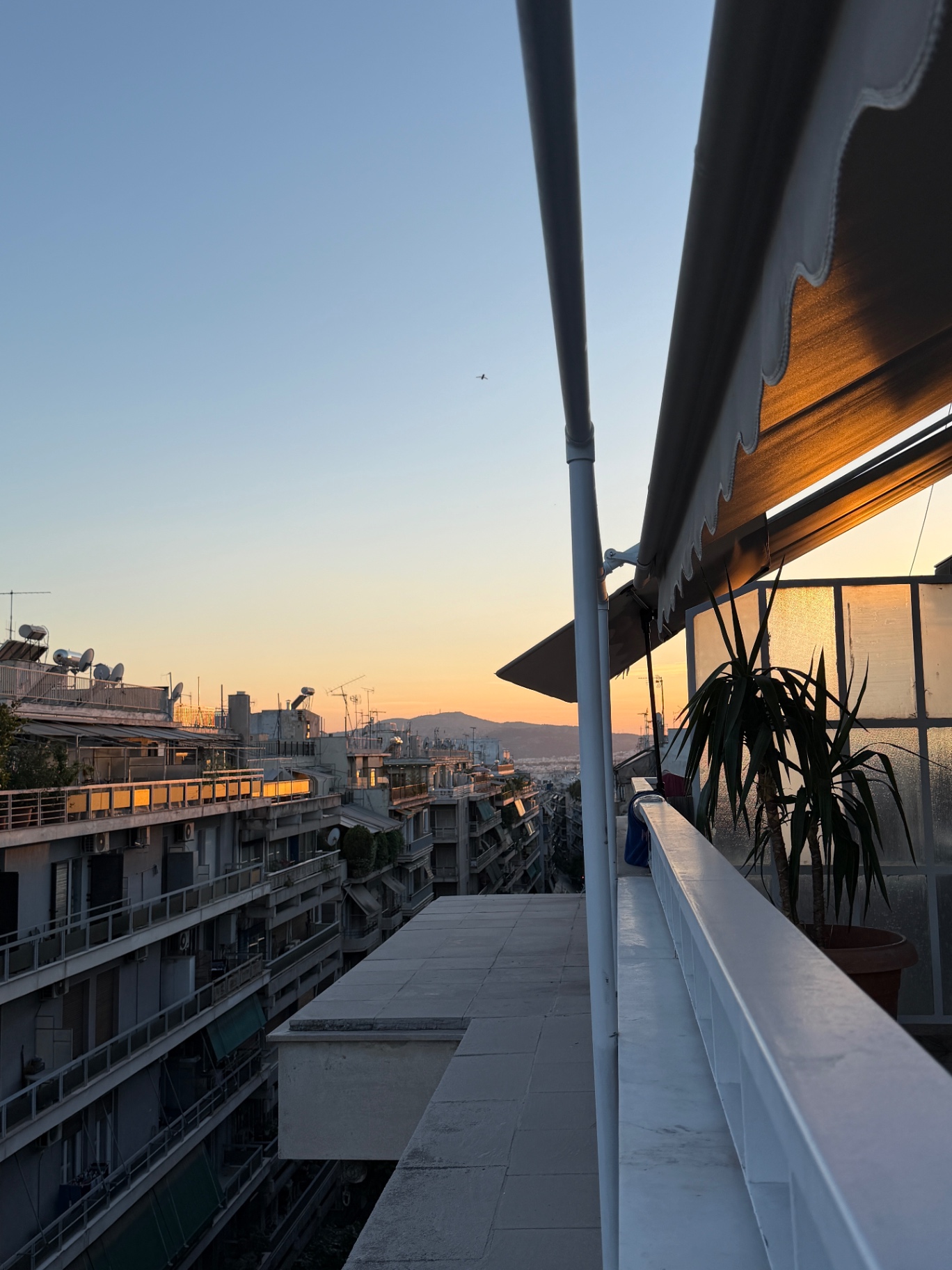Golden-hour skyline from the balcony looking over central Athens