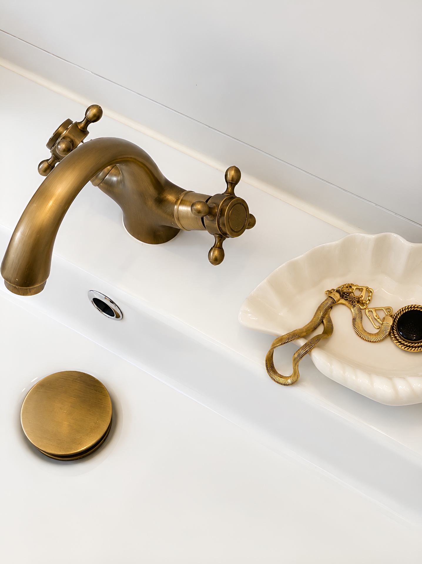 Antique brass faucet with shell dish and vintage jewellery