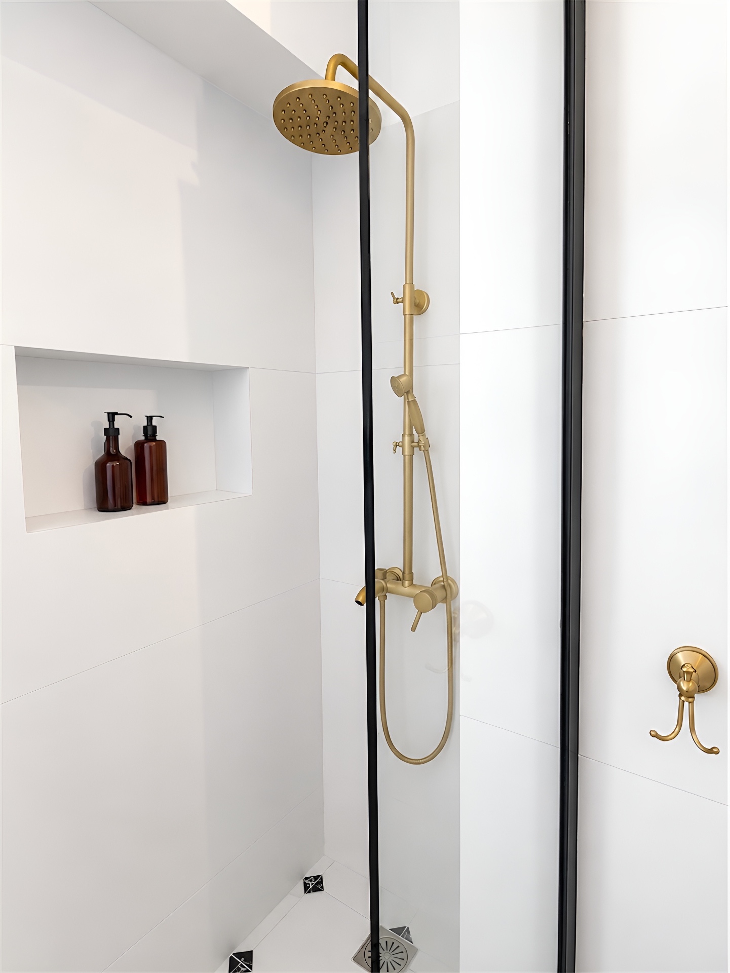 Brass rainfall shower against bright white tile